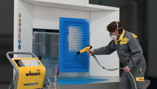 person using a Wagner manual powder coating systems gun to cover a panel